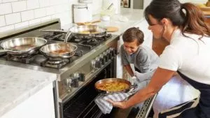 Femme avec un enfant qui sort une tarte d'un four