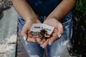 Argent dans mains avec une écriture "Make a change" sur un papier